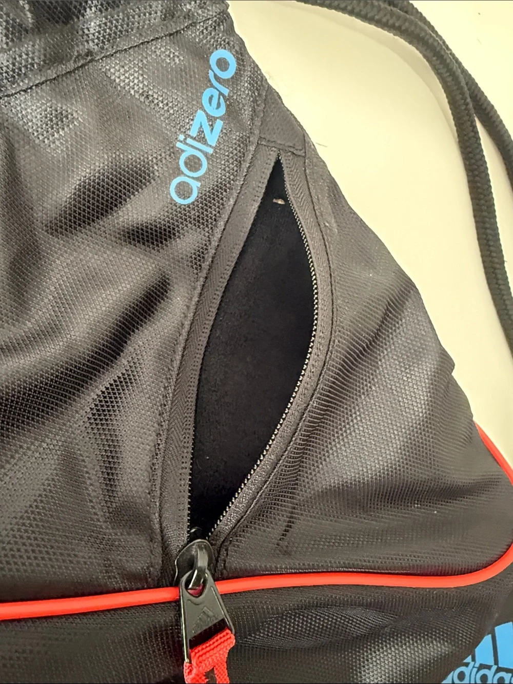 adidas Black Drawstring Backpack with Blue Stripes and Red Accents